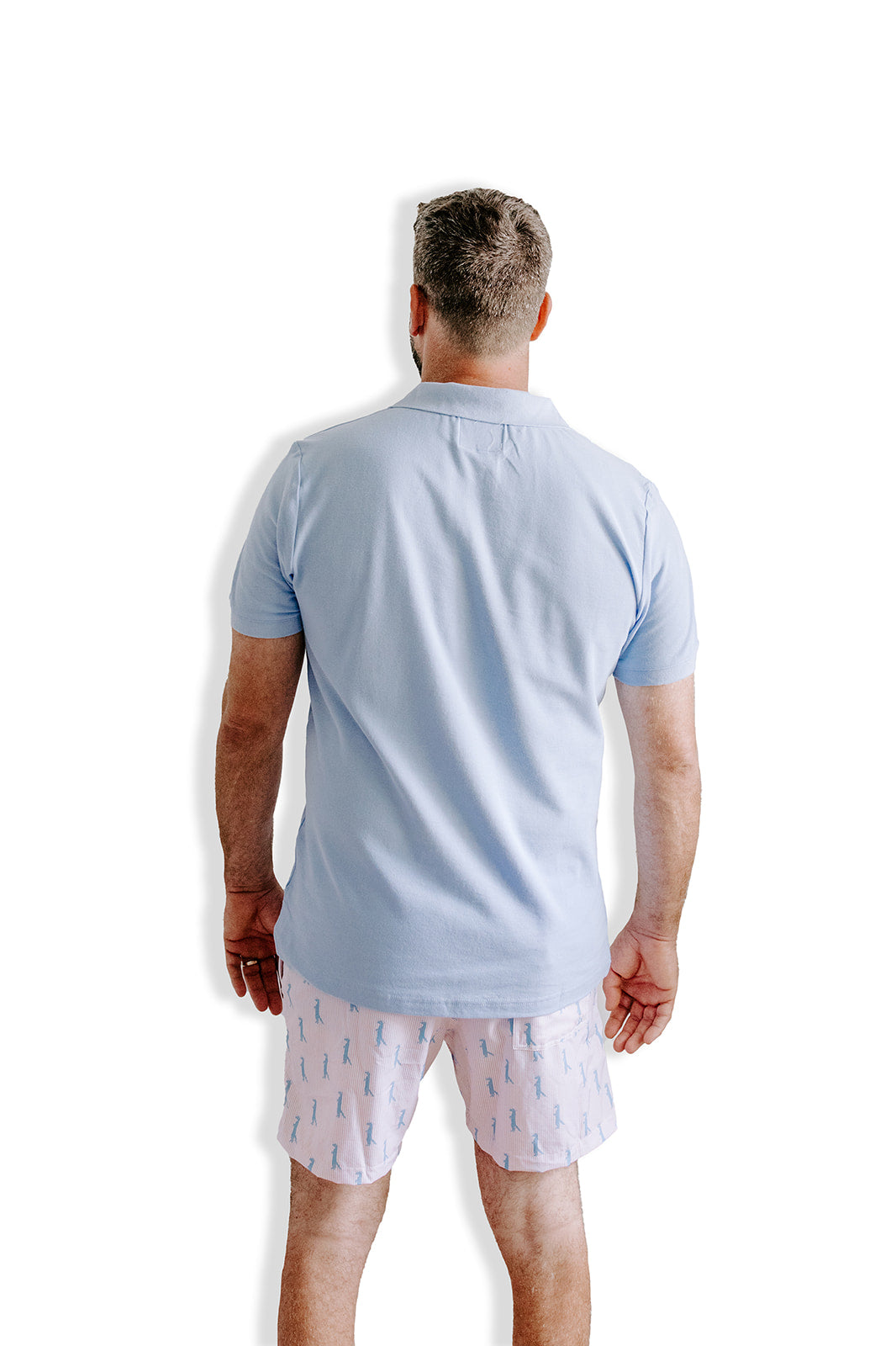 Beautiful knit polo in our signature Chambray blue with peach and white striping on the inside collar. Embroidered with our Saint Mongoose in peach on the left chest.  100% cotton